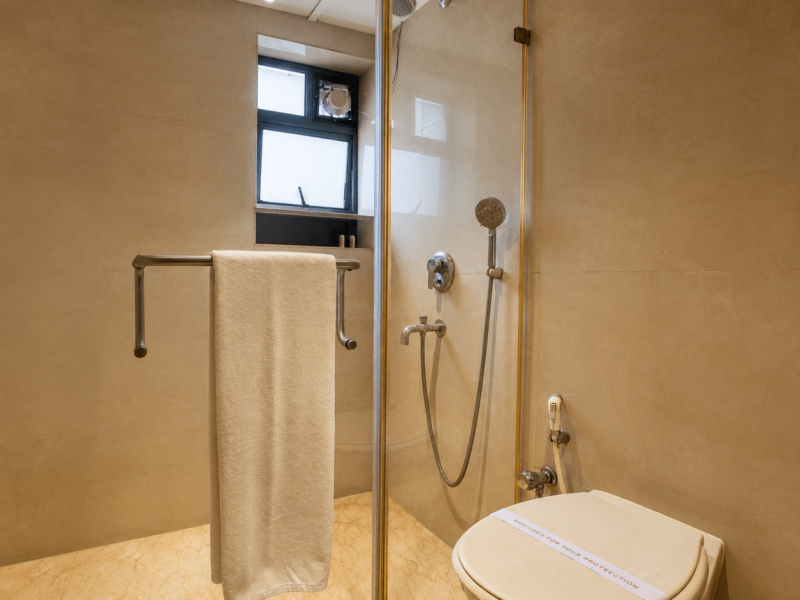 Comfortable deluxe hotel bathroom in Kolkata with glass-enclosed shower