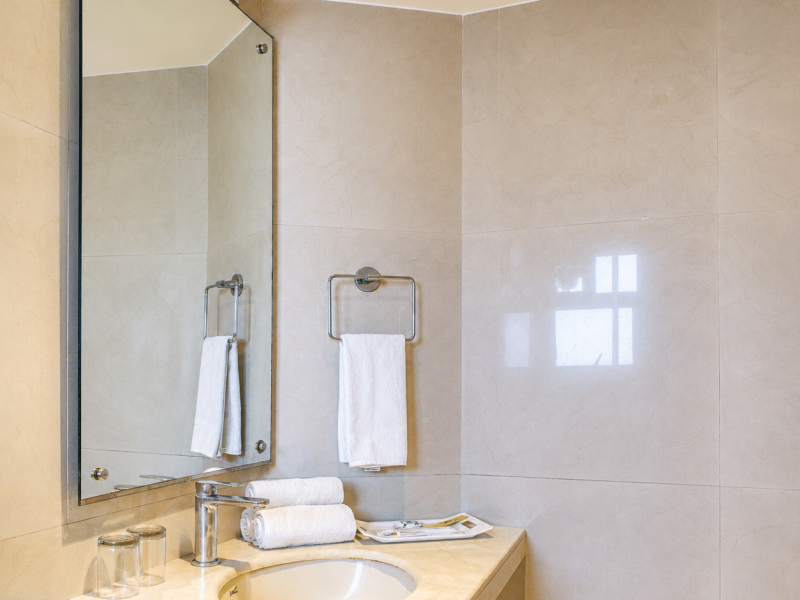 Deluxe room bathroom in Kolkata with vanity, mirror and premium toiletries