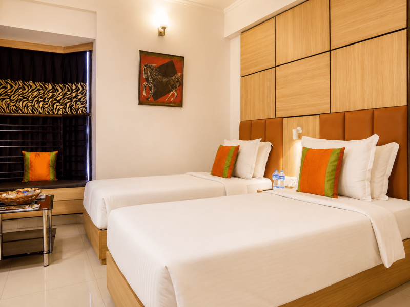 Premium room Kolkata with twin bed and Bay window Seating at Roland Hotel